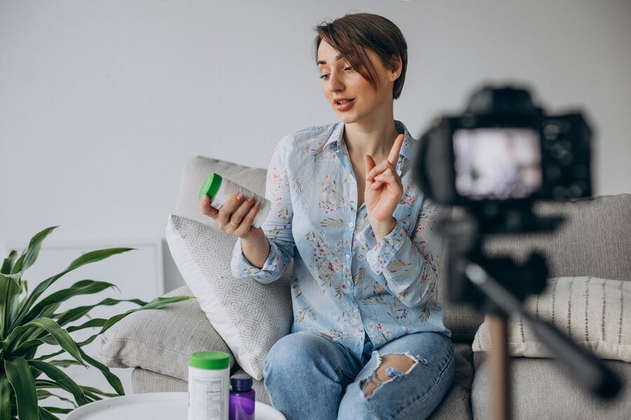 Jovem blogueira gravando vídeo para a câmera