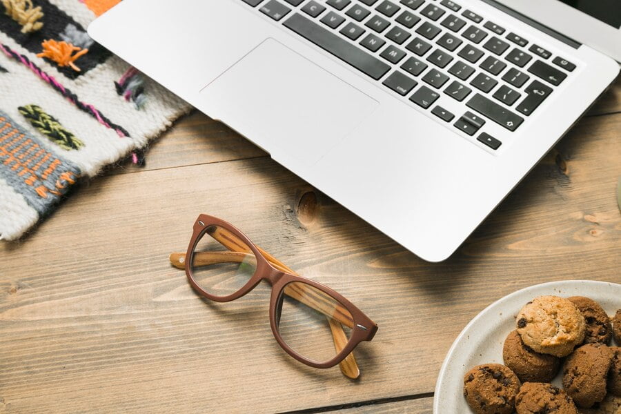 Área de trabalho de escritório com um laptop e um óculos