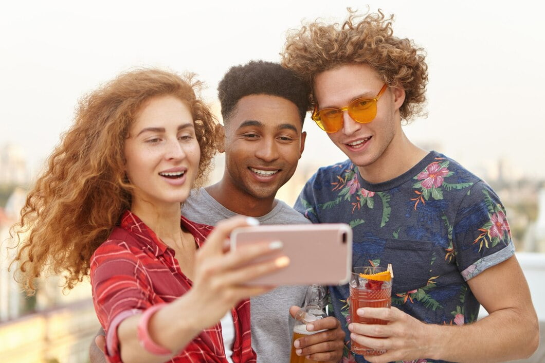 Homem e seus dois amigos com cabelos cacheados tirando selfies
