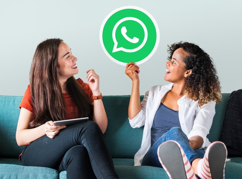 Mulheres jovens mostrando um ícone do whatsapp messenger
