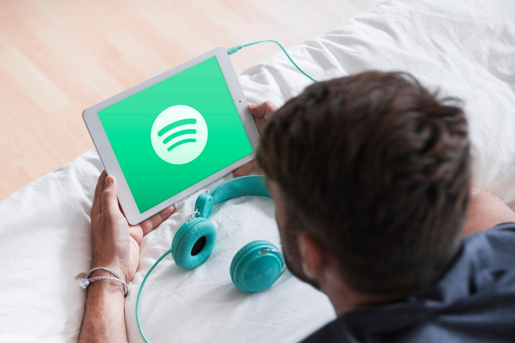 Homem jovem, segurando, moderno, dispositivo, com, spotify, app 