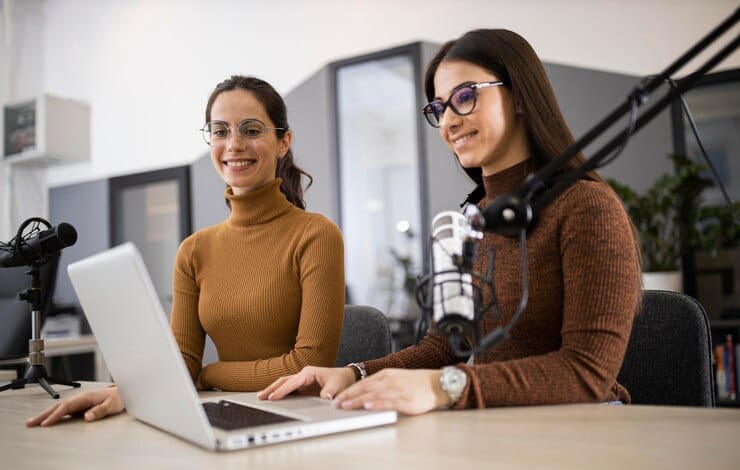 Mulheres sorridentes transmitindo no rádio
