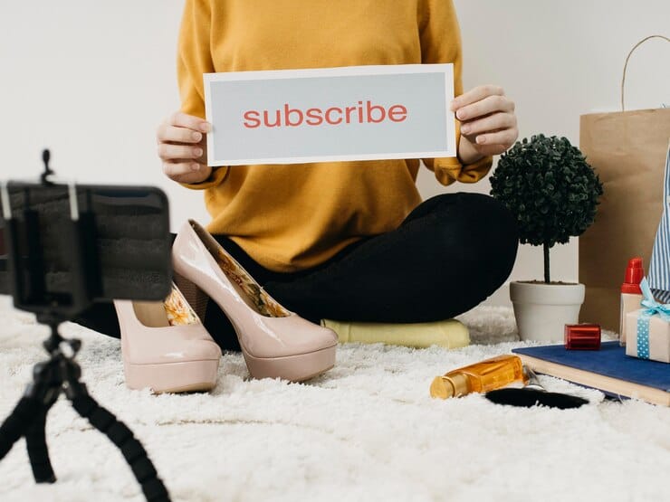 Blogueira de moda feminina fazendo streaming em casa com smartphone e palavra de assinatura
