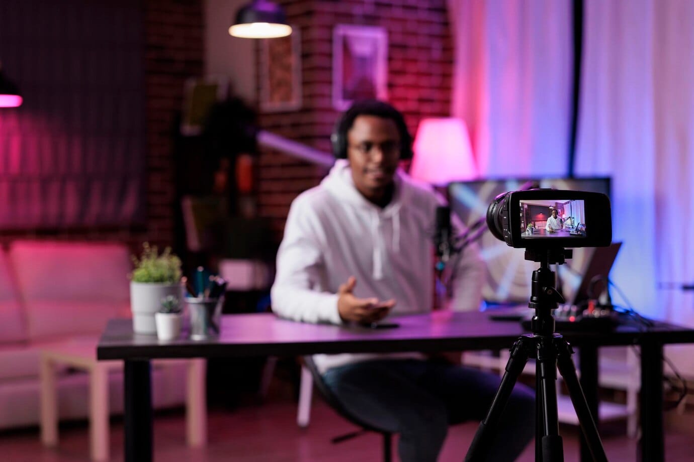 Jovem filmando episódio de podcast na câmera em estúdio
