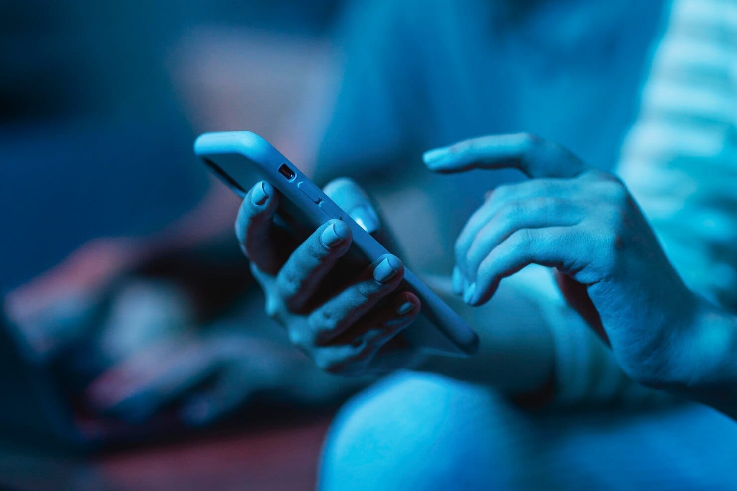 10 sinais de que sua empresa precisa de gestão de mídias sociais agora Mulher usando seu smartphone enquanto está em casa