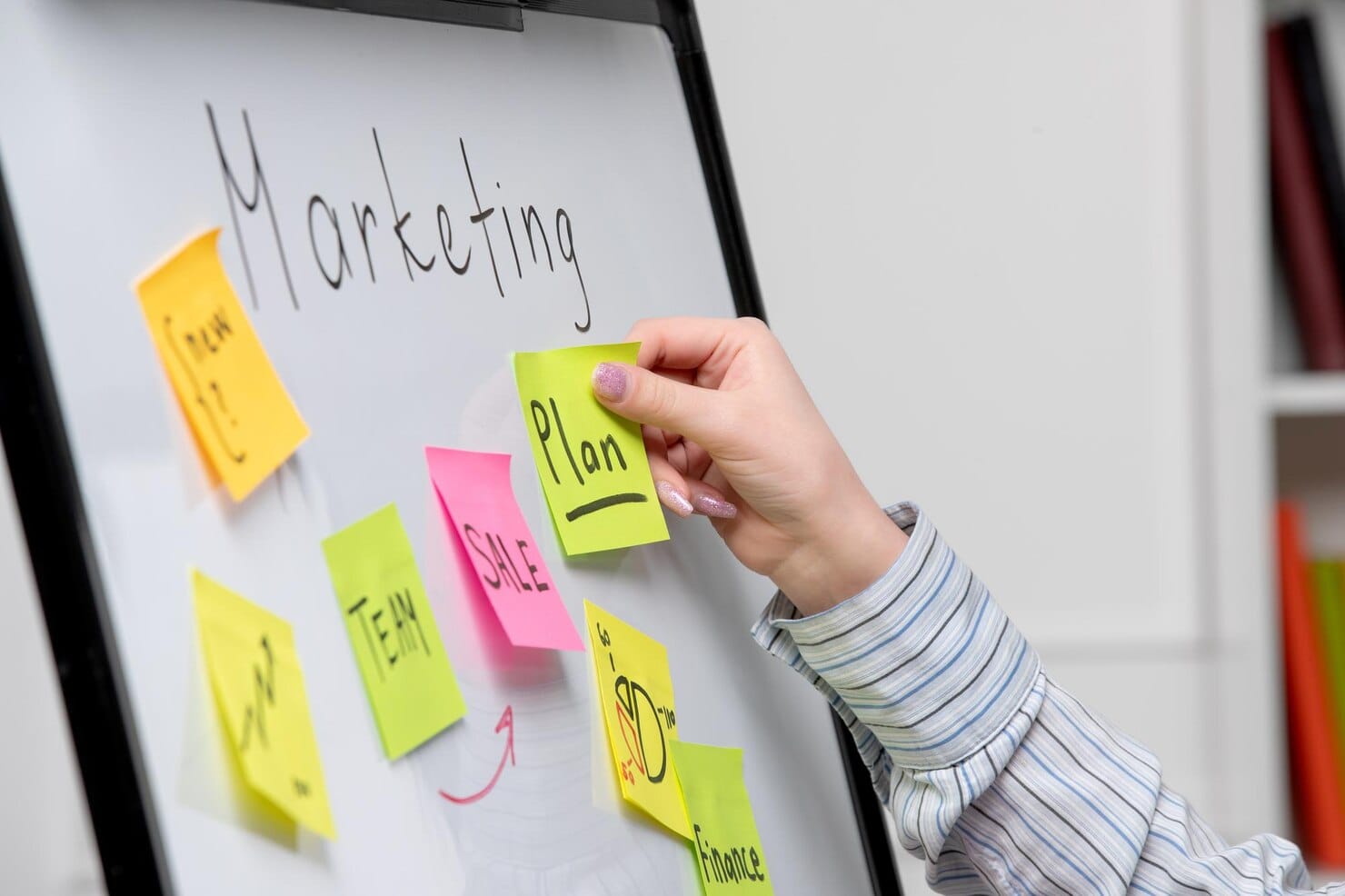 Planejamento que começa com o comportamento do cliente Marketing jovem mulher de negócios bonita em camisa listrada no escritório criando novo plano de marketing