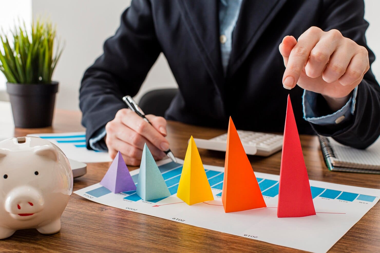 Vista frontal do empresário com cones coloridos que representam o crescimento

