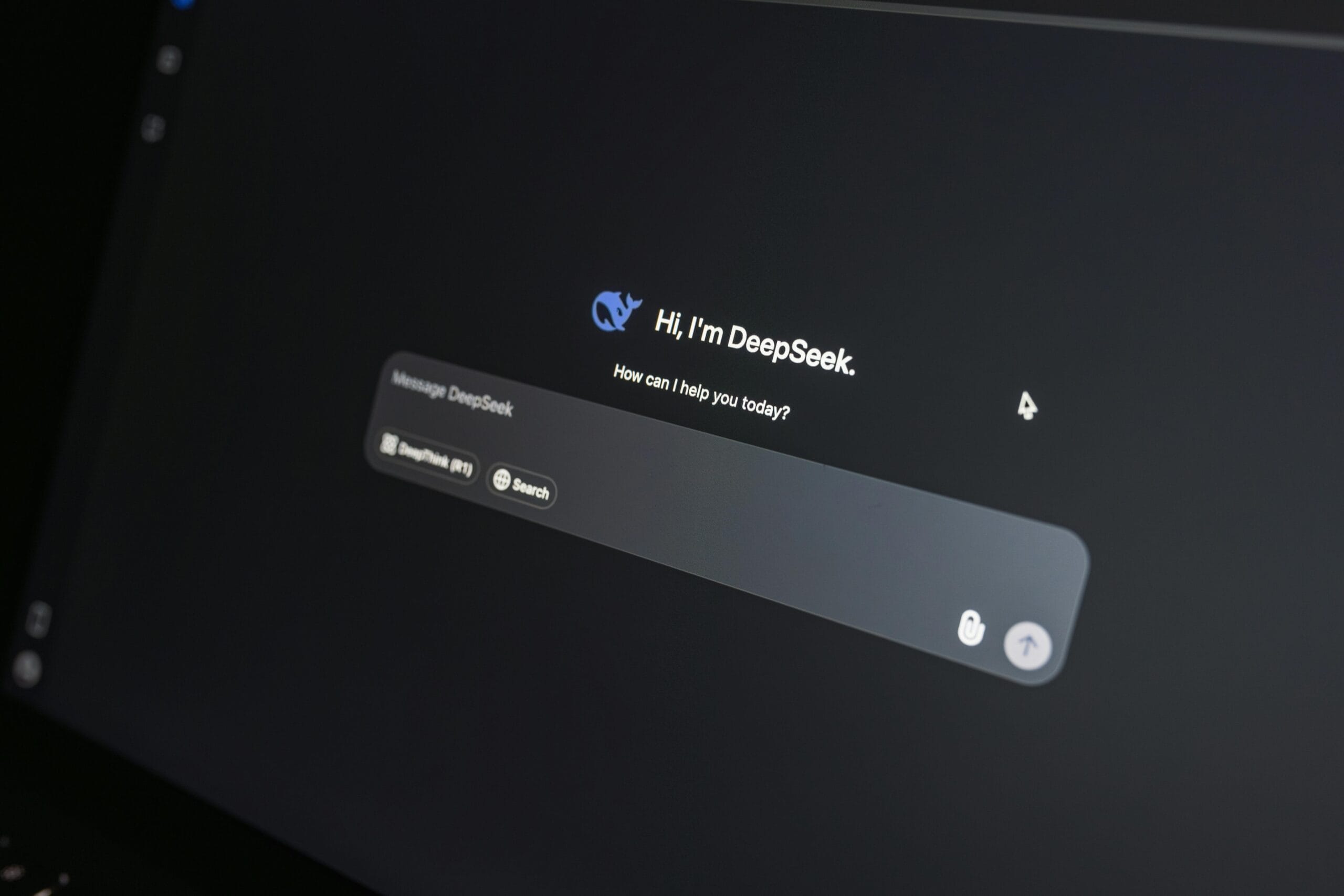 Close-up da interface de bate-papo do DeepSeek AI na tela de um laptop com pouca luz