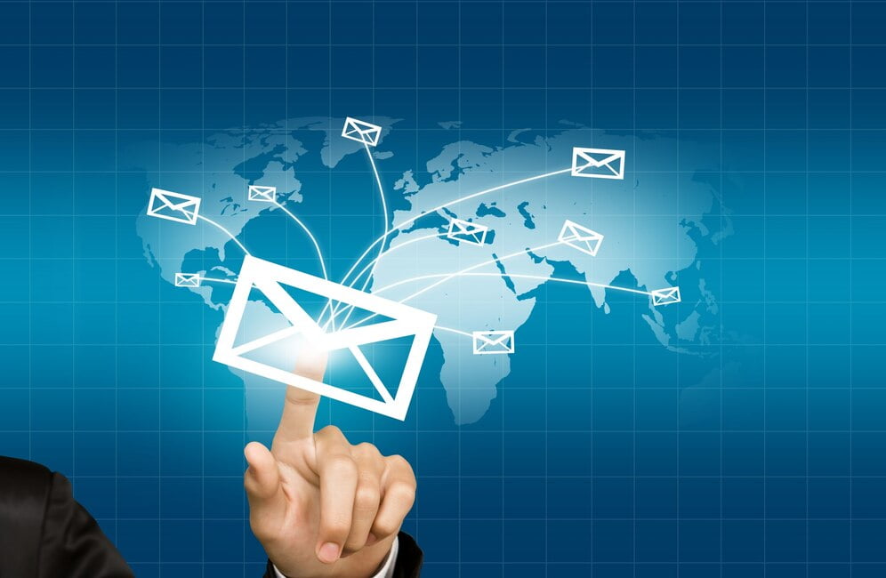 Mão pressionando um envelope que é enviado para o mundo