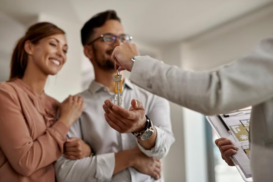 Close de um agente imobiliário dando a algumas chaves de sua nova casa