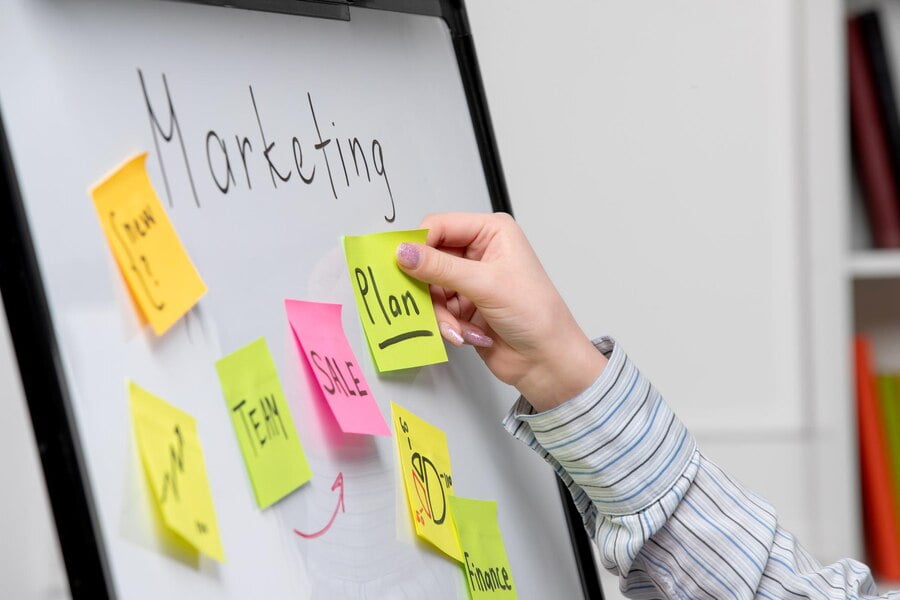 Marketing 360: o que é e os segredos por trás da estratégia 1 Marketing jovem empresária bonita em camisa listrada no escritório, criando um novo plano de marketing