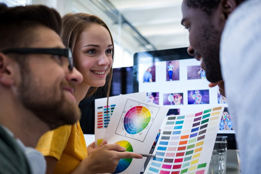 Além do Visual: a Influência Das Cores no Branding 1 Grupo de designers gráficos que escolhem a cor de uma cartela de cores