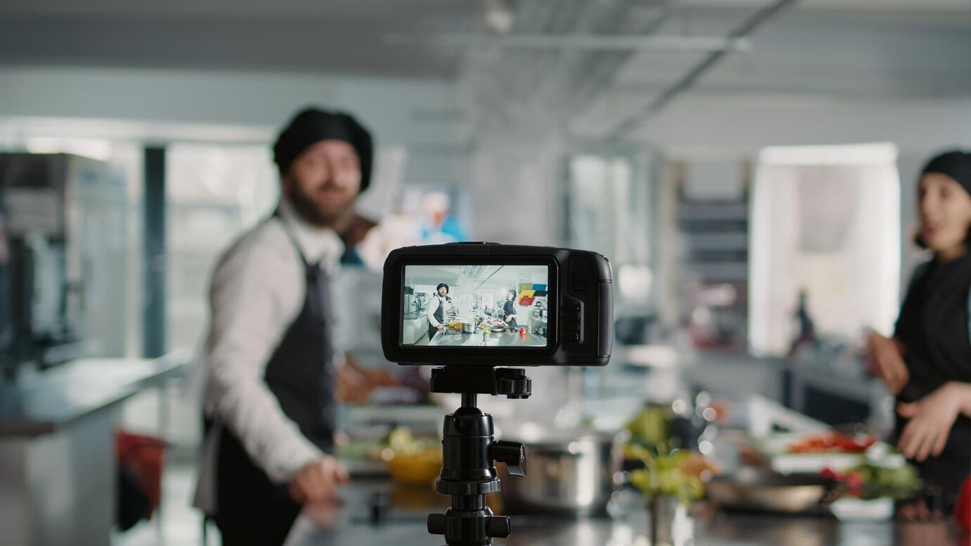 El futuro del marketing en vídeo con Shorts Ads Câmera filmando pessoas cozinhando prato de menu profissional na cozinha, gravando vlog online para programa de gastronomia