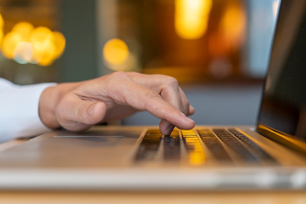 Homem digitando no laptop com bokeh
