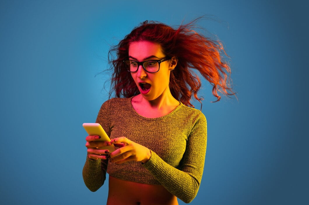 Retrato de uma mulher caucasiana isolado em um fundo azul do estúdio em luz de néon. Linda modelo feminino com cabelo ruivo. Conceito de emoções humanas, expressão facial, vendas, anúncio.