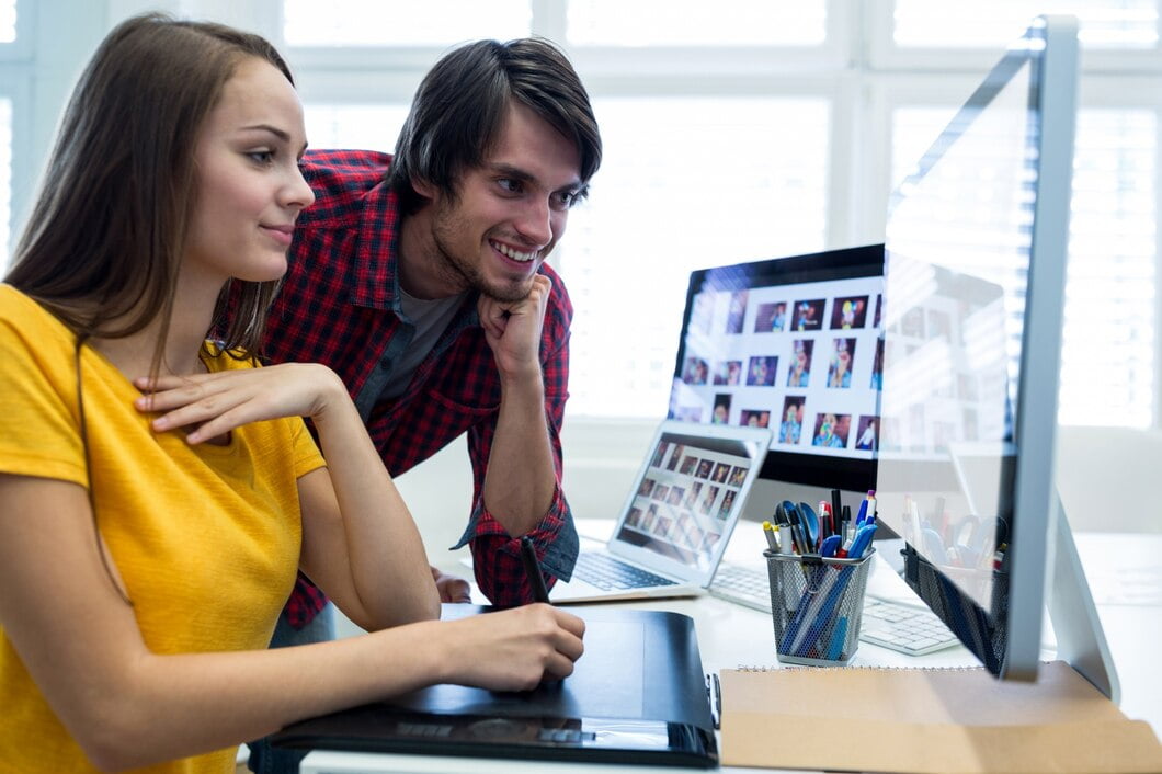 Designers gráficos masculinos e femininos usando gráficos tablet