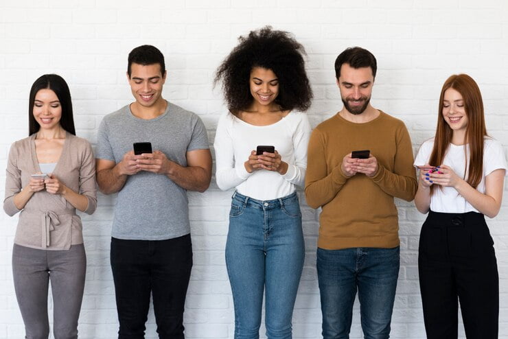 Comunicação direcionada para Millennials Vista frontal do grupo de pessoas que enviam mensagens de texto em seus telefones celulares