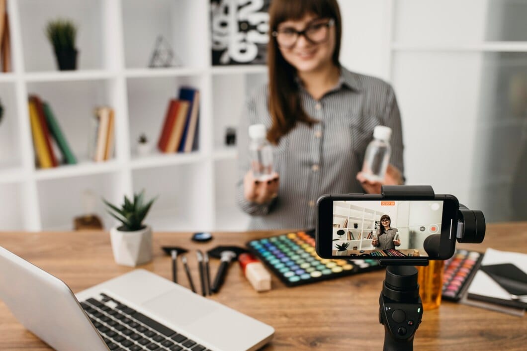 Blogueira de maquiagem feminina com streaming com smartphone e laptop