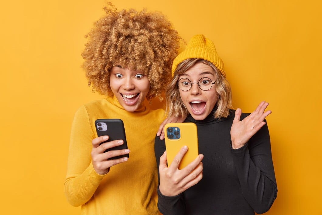 Tecnologia e conceito de amizade Mulheres loucas e positivas usam telefones celulares 
