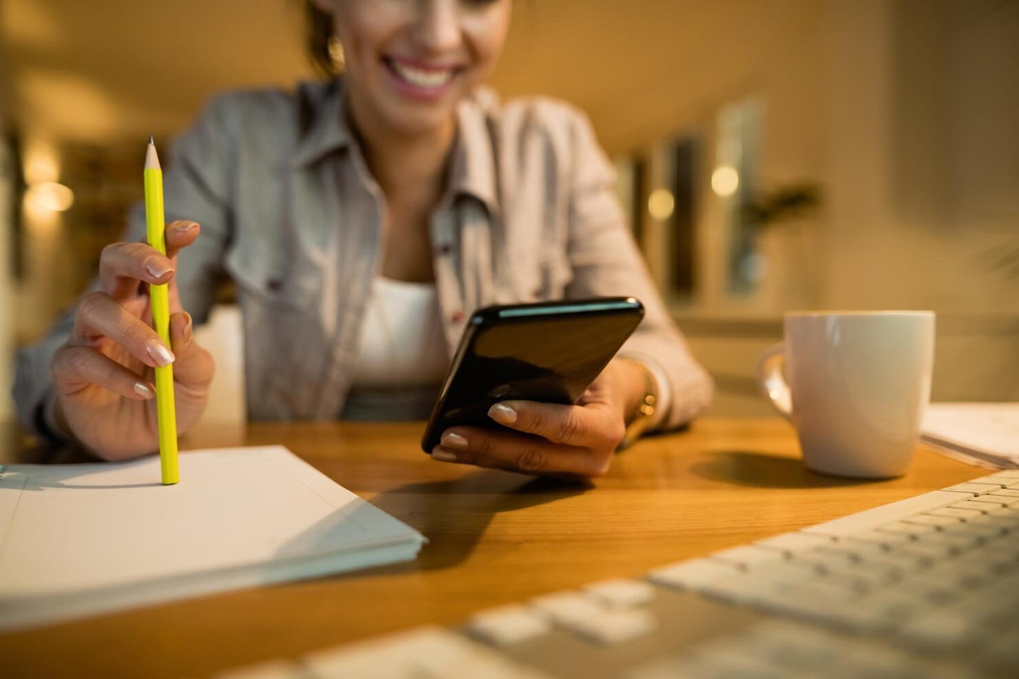 Copywriting: A Arte de Converter Leitores em Consumidores Closeup de mulher usando telefone inteligente enquanto aprende à noite em casa