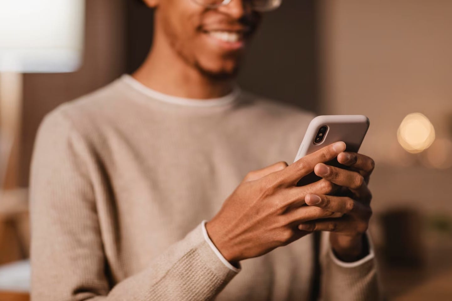Homem sorridente usando smartphone moderno