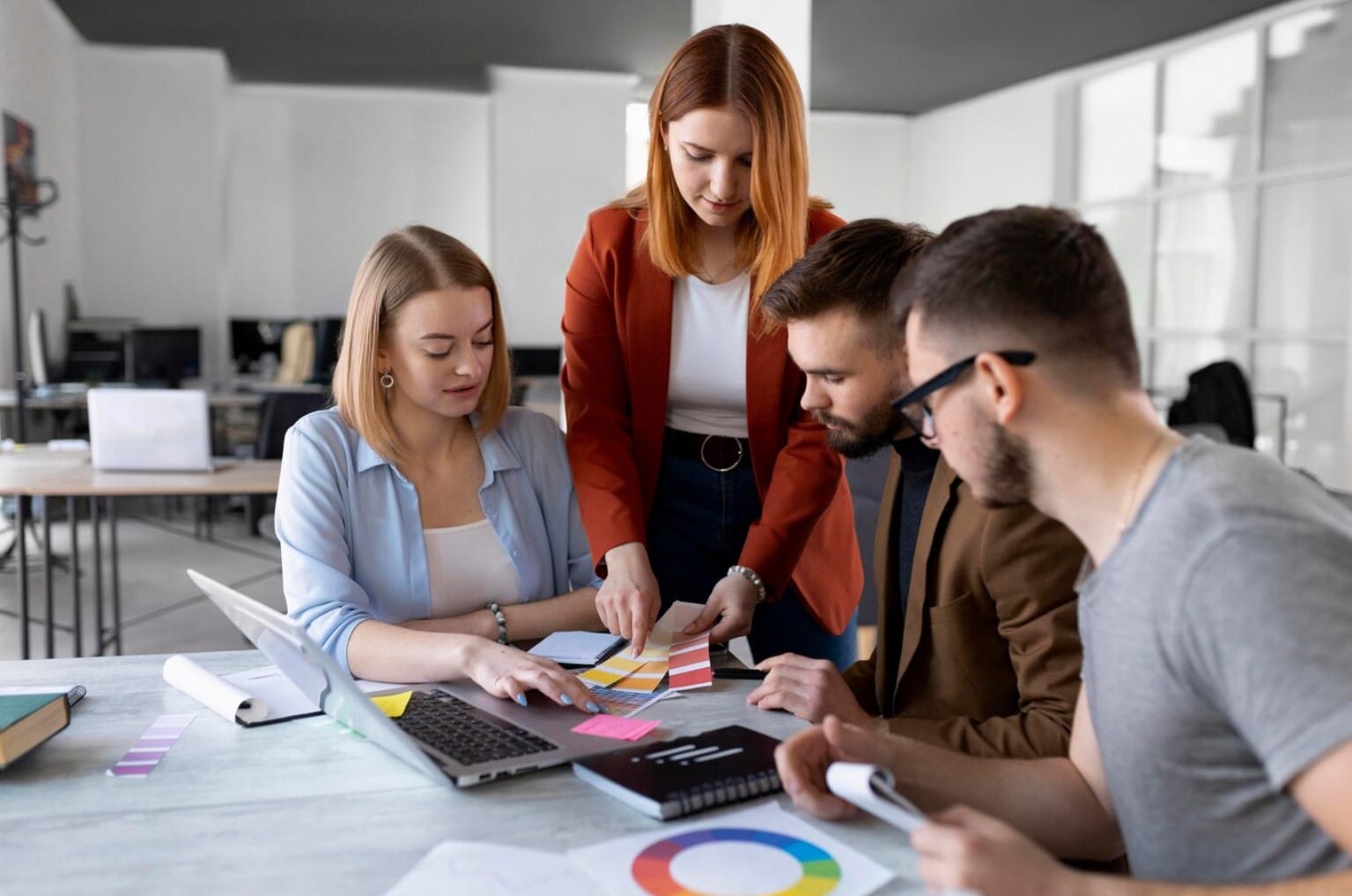 Como escolher a melhor agência para desenvolvimento de sites e apps? Pessoas fazendo um brainstorming em uma reunião de trabalho