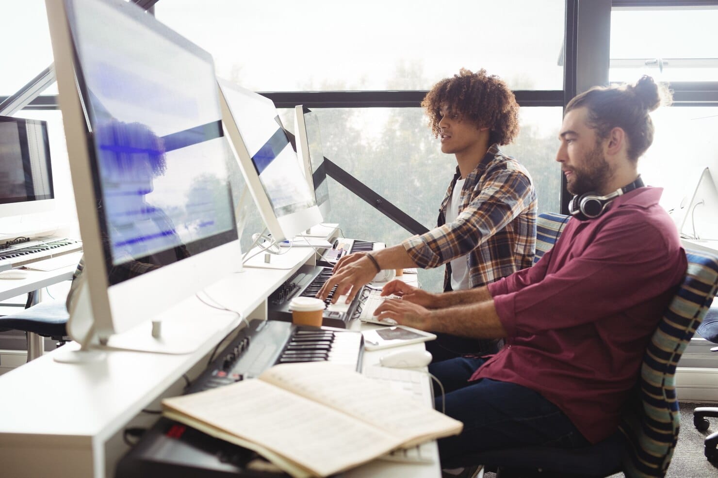 Software house: o motor por trás das fintechs de sucesso Dois engenheiros de som trabalhando juntos