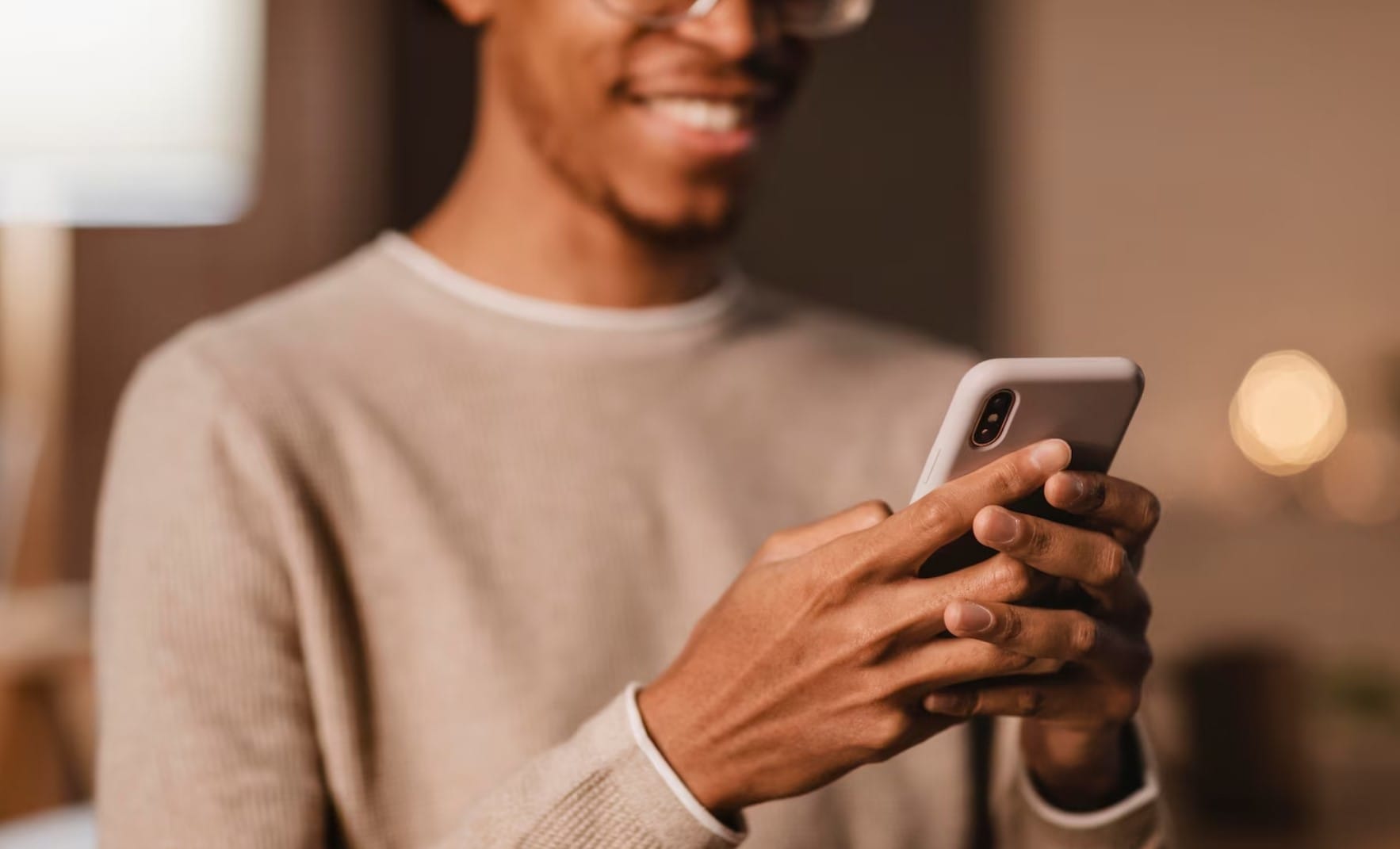 Descubra como transformar seu app em um canal de aquisição de clientes Homem sorridente usando smartphone moderno