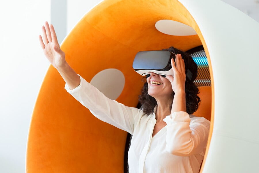 Marketing no Metaverso: Tudo Sobre essa Tendência Digital 2 Mulher de negócios espantado no fone de ouvido vr tocando o ar
