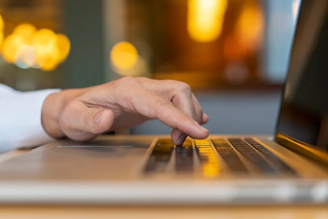 Increasing Click-Through Rates or Conversions? Which is Better? Homem digitando no laptop com bokeh