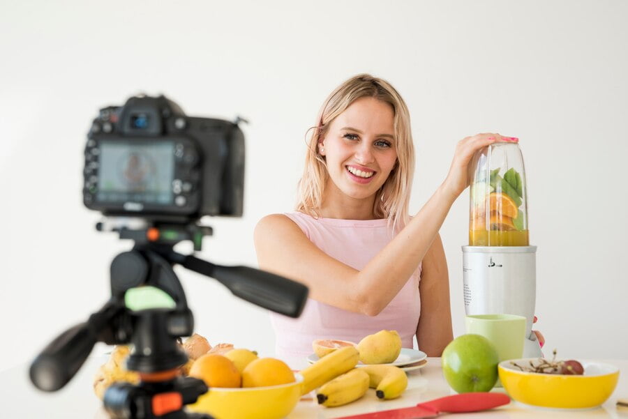 Como criar uma estratégia de conteúdo com especialistas? Influenciador loira gravando comida nutrição