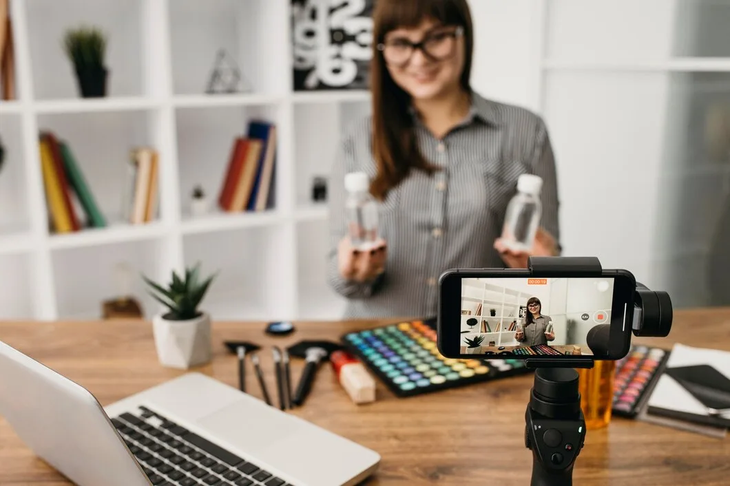 A importância dos vídeos imersivos para suas estratégias de marketing Blogueira de maquiagem feminina com streaming com smartphone e laptop