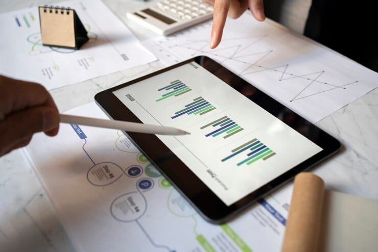 Acompanhamento e análise de resultados Pessoas de negócios trabalhando com ipad em ângulo alto