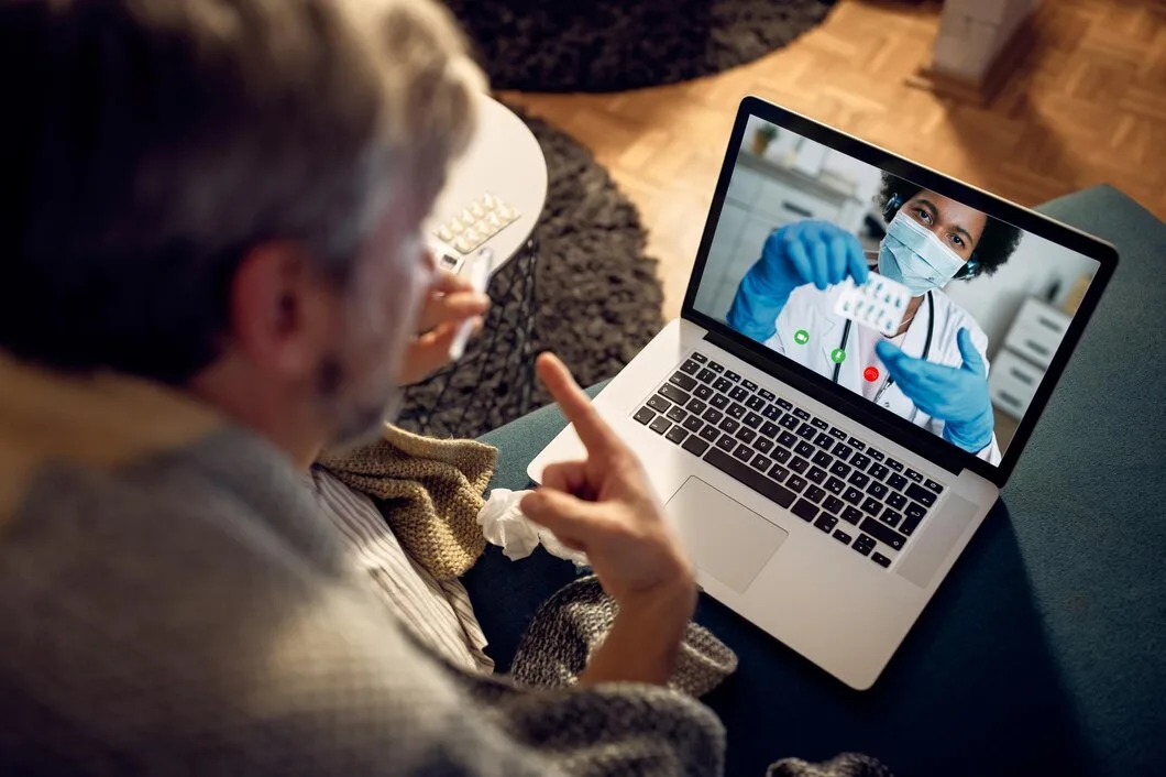 7 estratégias omnichannel para a indústria farmacêutica Closeup de homem tendo chamada de vídeo com seu médico à noite em casa