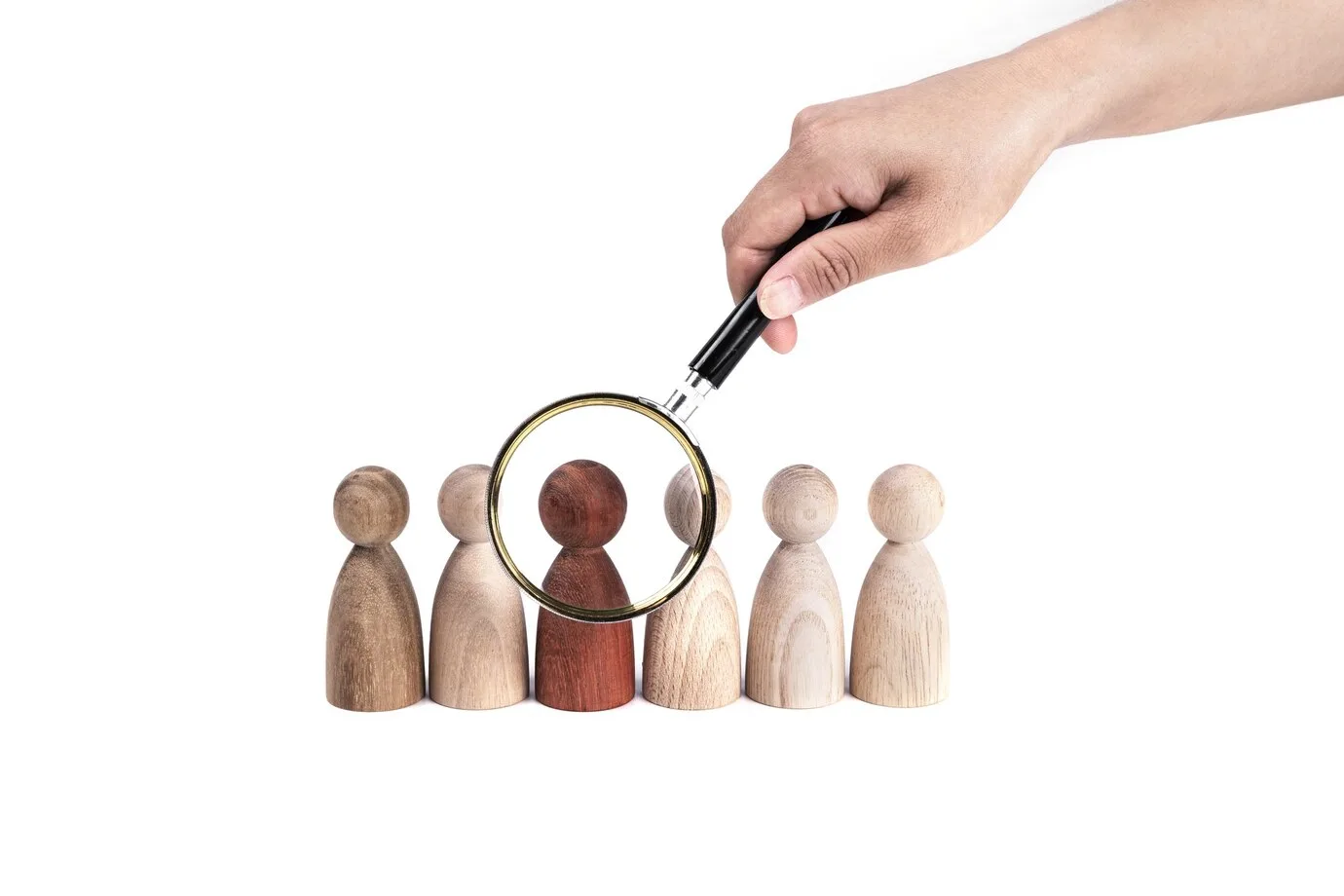 Benefícios do marketing inteligente para as empresas Mão segurando uma lupa sobre uma estatueta vermelha em uma fileira