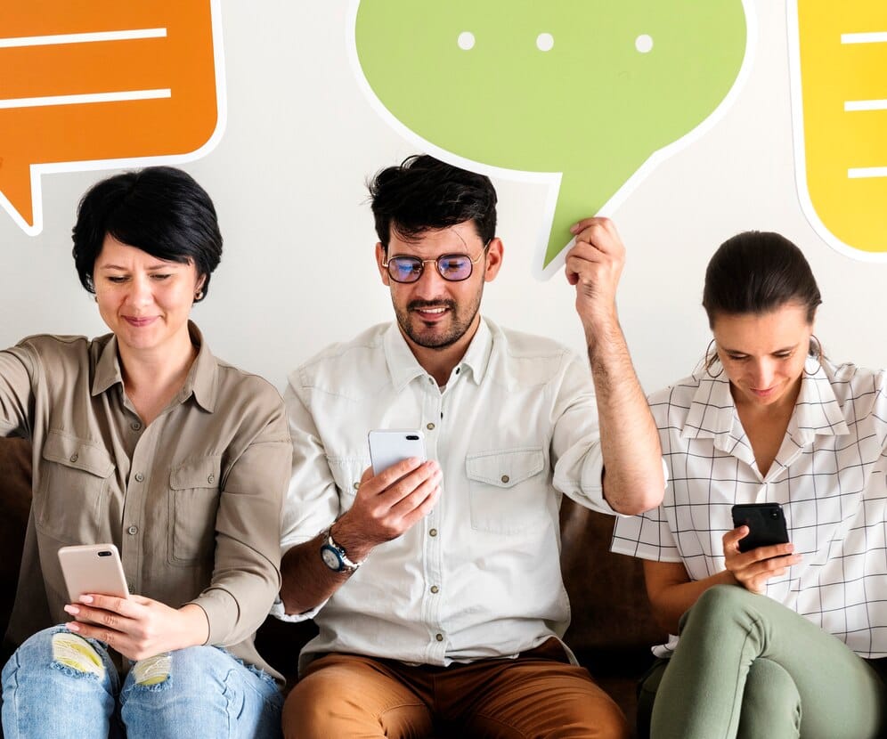 Social Listening: O Que É e Como Aplicar na Sua Marca Colegas de trabalho sentado no sofá e segurando os ícones de mensagem