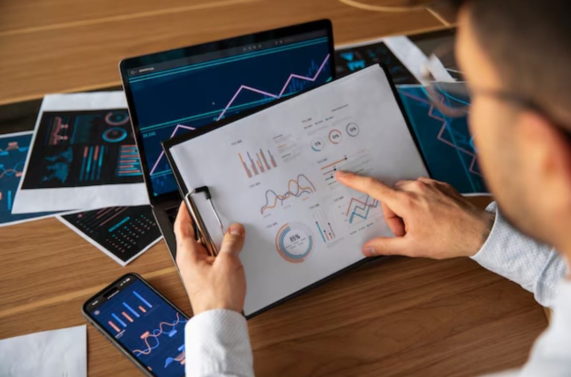 Insights de Dados: O Que Toda Agência Criativa Precisa Saber Trabalhadores de escritório usando gráficos de finanças