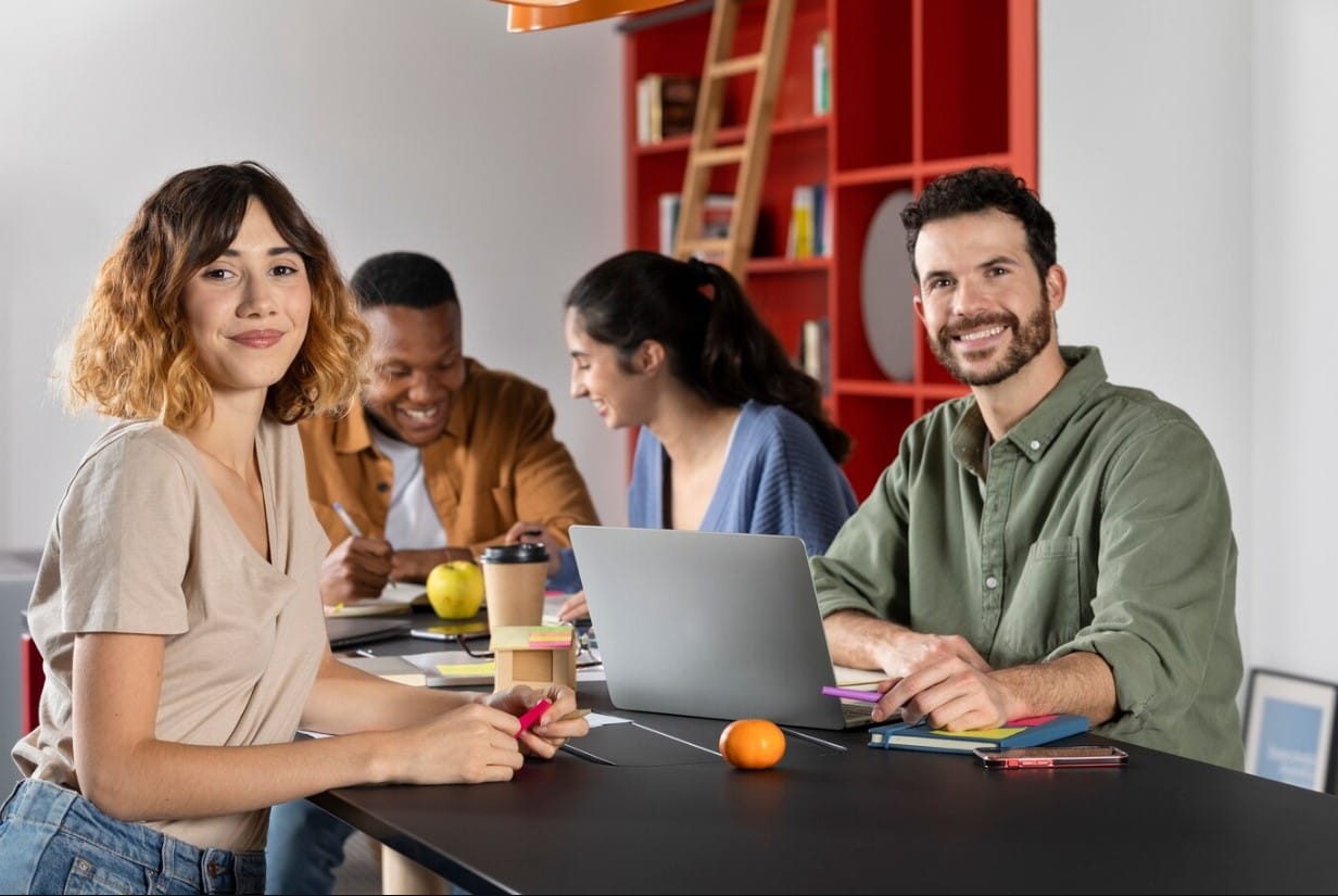 Times pequenos, grandes entregas: hacks de produtividade que realmente funcionam Colegas aprendendo e sorrindo durante a sessão de estudo