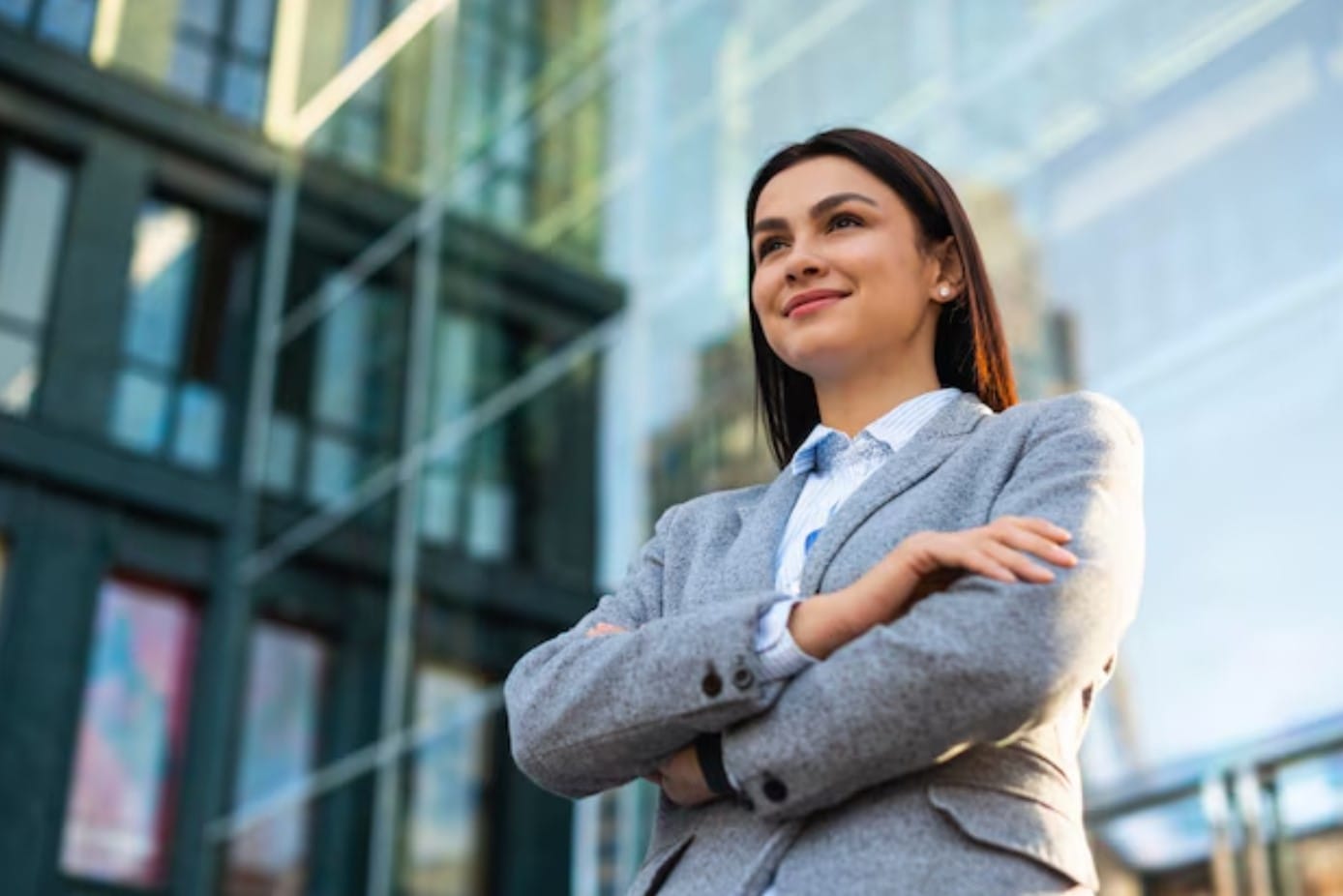 Dicas infalíveis para fortalecer seu personal branding Mulher de negócios posando com os braços cruzados na cidade
