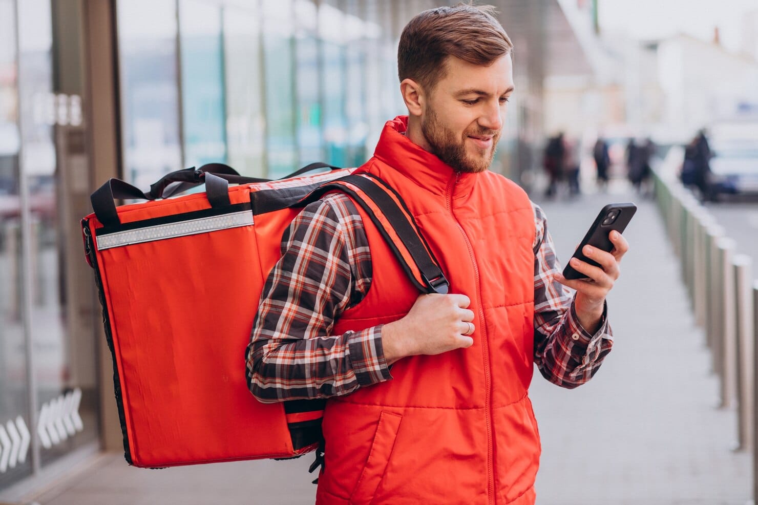 10 dicas práticas de marketing para delivery para atrair mais clientes Um entregador de comida com caixas de comida.