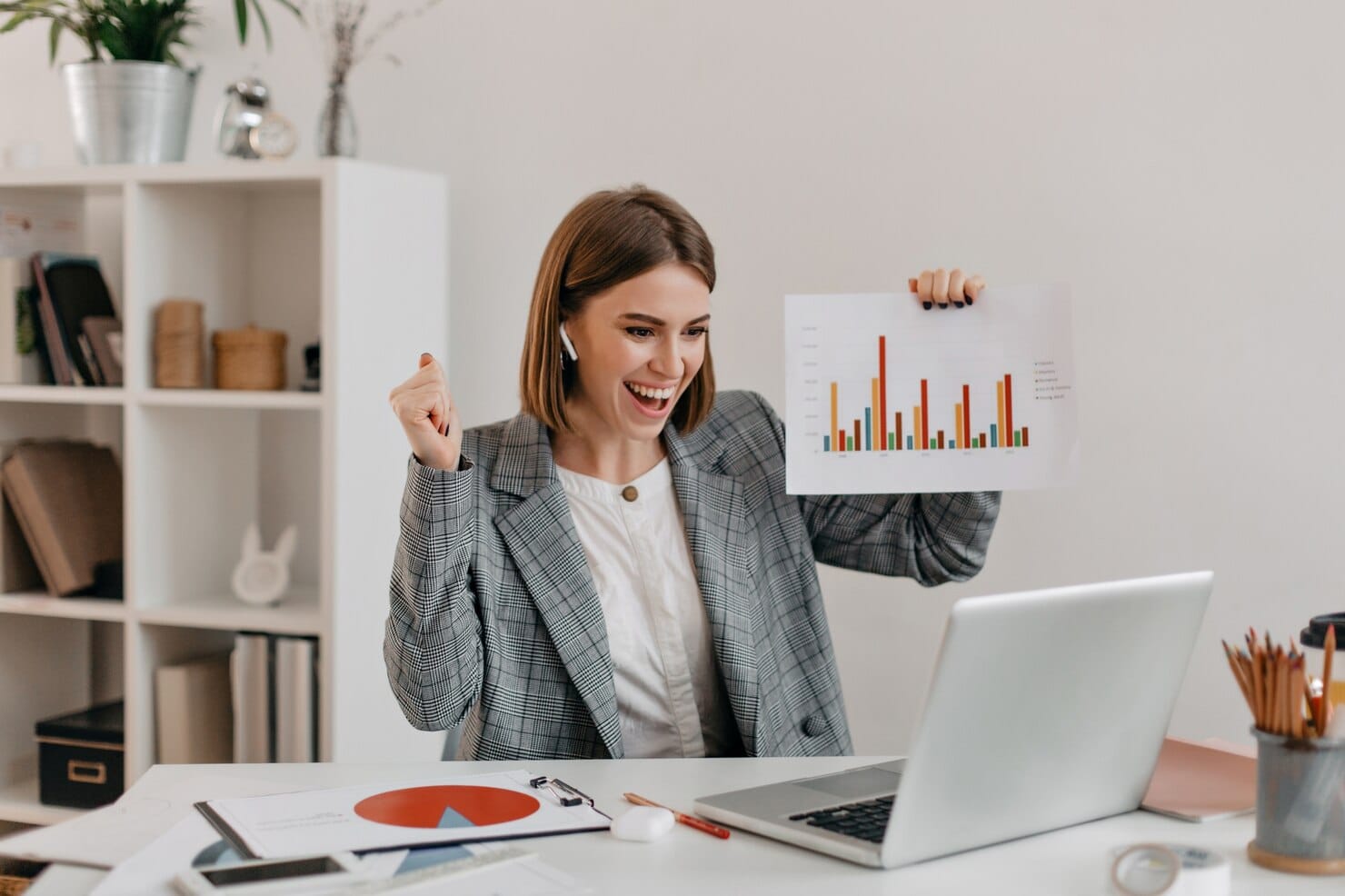 Dicas para aumentar o ROI com marketing de performance Retrato do close-up de mulher de negócios feliz com roupa elegante. Menina de bom humor demonstra gráfico via Skype.