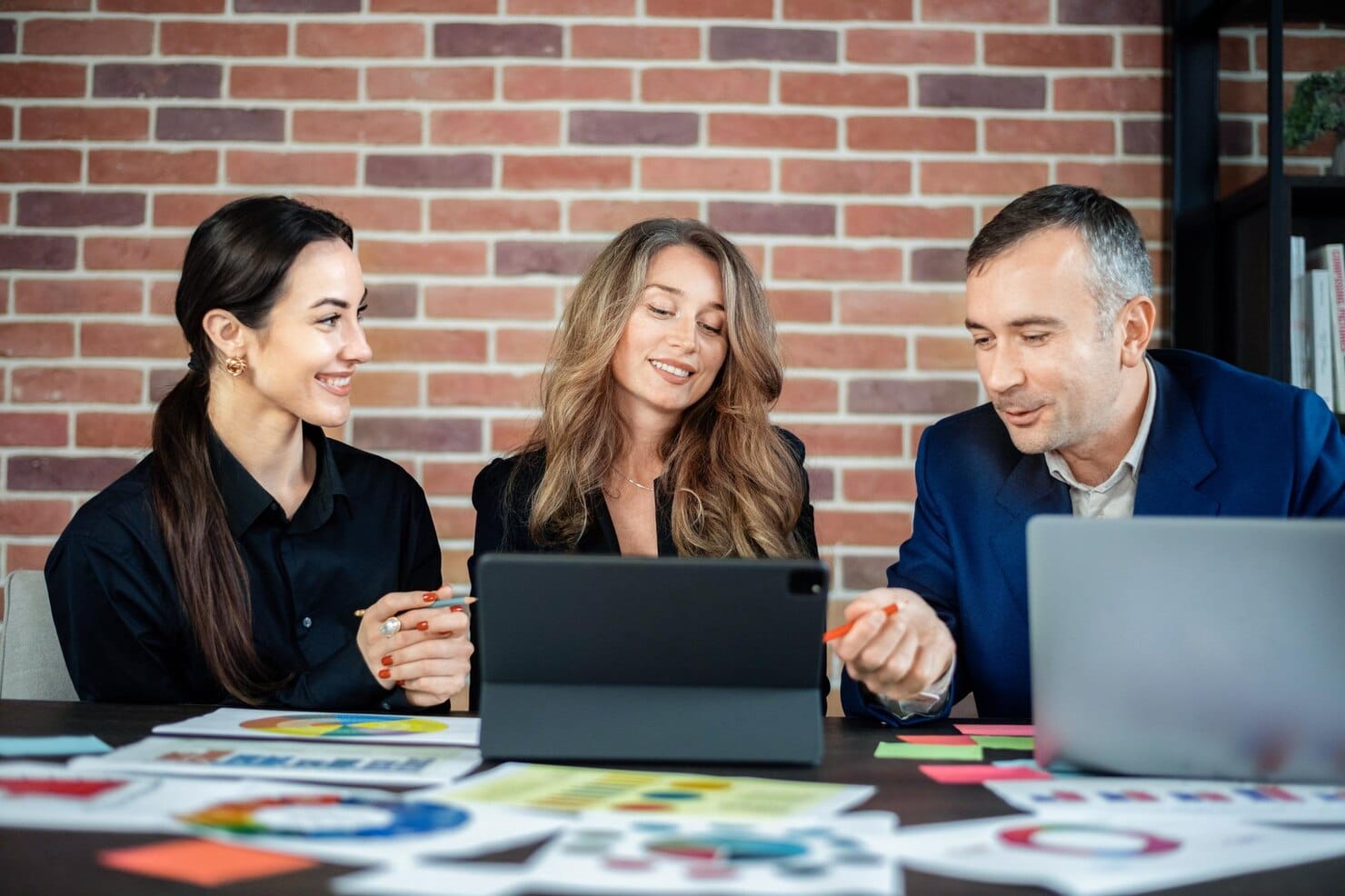 7 sinais de que sua empresa precisa de uma consultoria de marketing urgentemente Sessão de negócios em um escritório Mulheres e um homem discutindo assuntos de negócios Gadgets e papéis