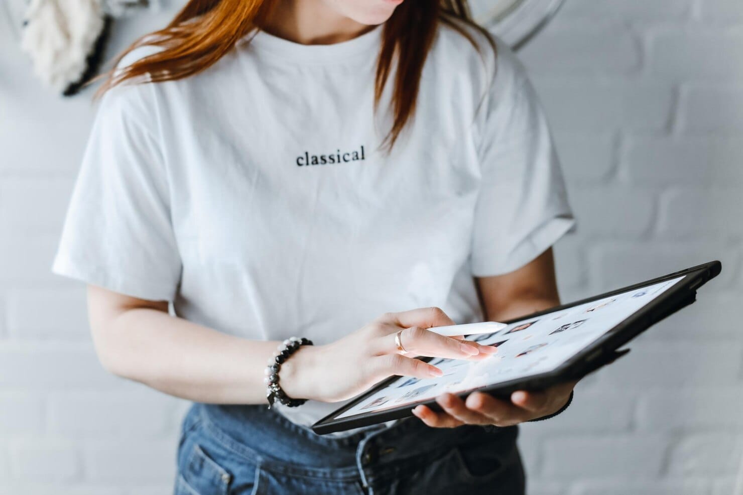 Merchandising digital: como aumentar a percepção da marca online Jovem garota desenhando em tablet dentro de casa