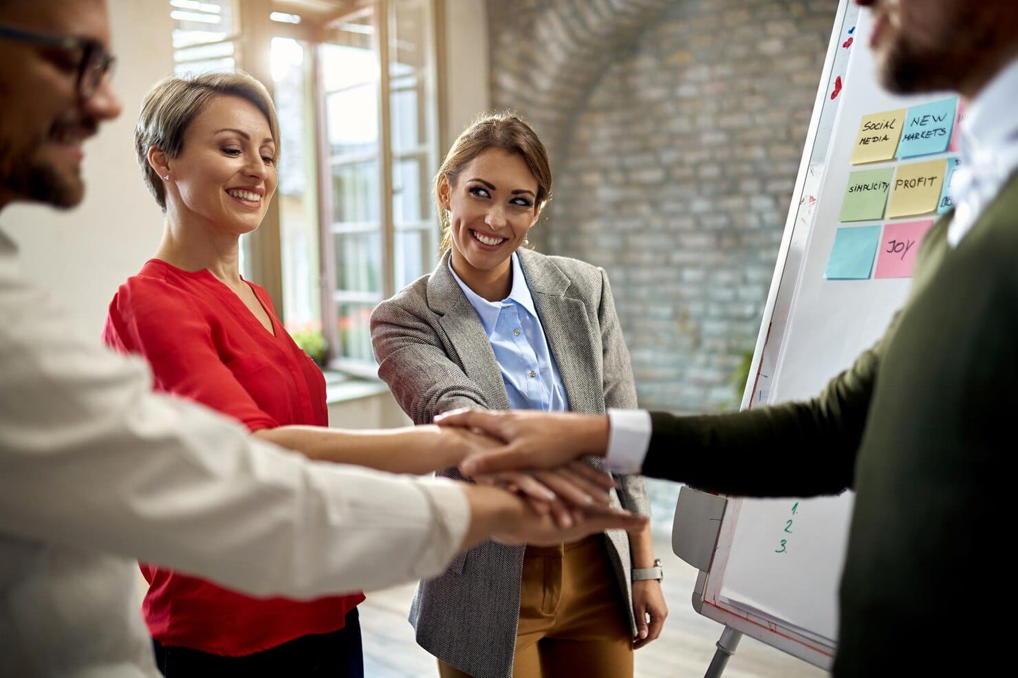 Equipe de empresários felizes reunindo suas mãos
