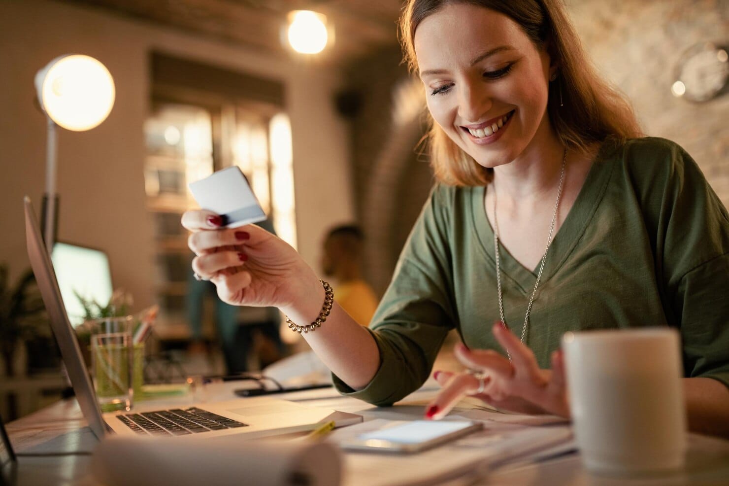 
Mulher de negócios feliz usando telefone inteligente e cartão de crédito